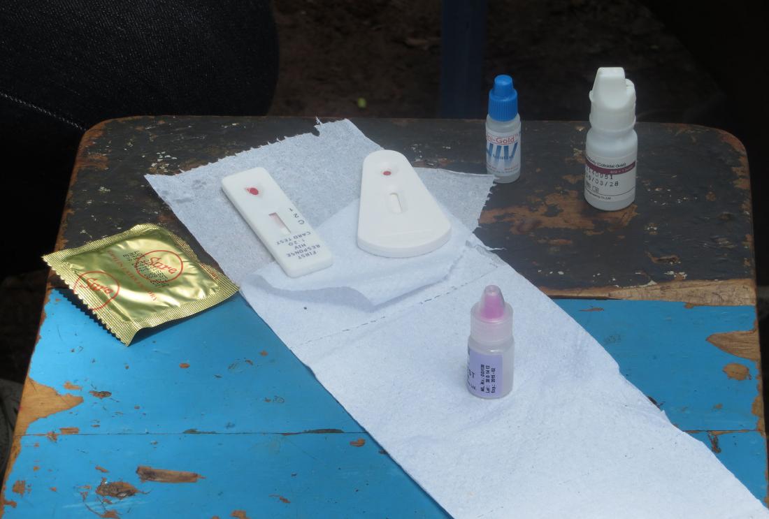 Table with condom, vials, and meters for HIV testing