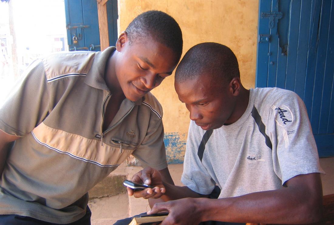 Two men look at mobile phone