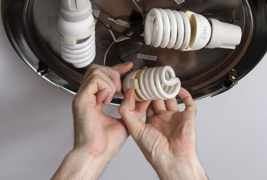 Electrician installing energy efficient lightbulbs