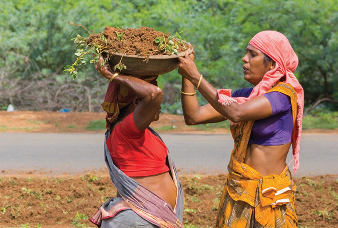 Women in India moving receptacles of dirt.