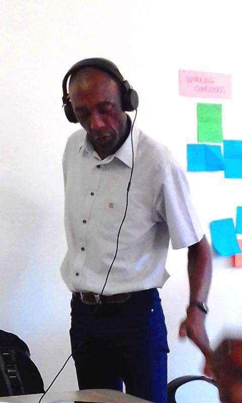 A standing man wearing headphones 