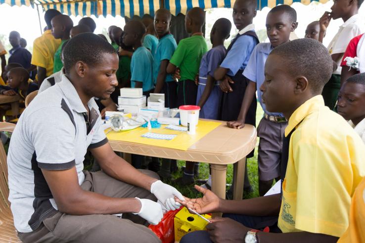 Photo: A health worker conducts a blood test on a client in Nkokonjeru, Uganda. Adam Jan Figel | Shutterstock.com