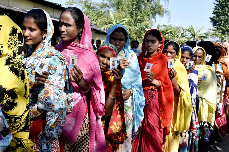 Women stand in line waiting to cast their vote at a polling station in in Barpeta, Assam, India.